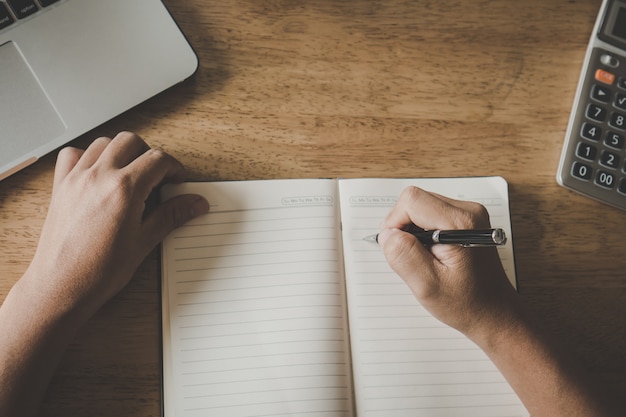 Cerrar la mano de notas de la escritura del estudiante.