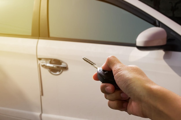 Cerrar mano sujetando las llaves sobre borrosa de coche usado