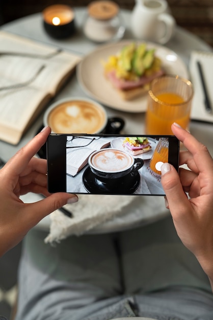 Cerrar la mano tomando una foto de café con el teléfono