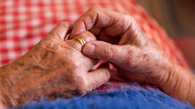 Cerrar las manos ancianas de una anciana viuda sosteniendo anillos abuela caucásica