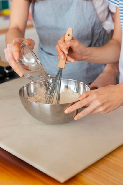 Foto cerrar las manos cocinando en la cocina