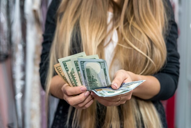 Cerrar las manos femeninas con billetes de dólar