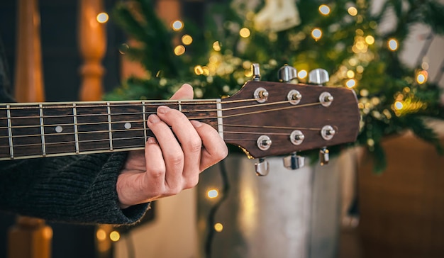 Cerrar manos femeninas tocando la guitarra