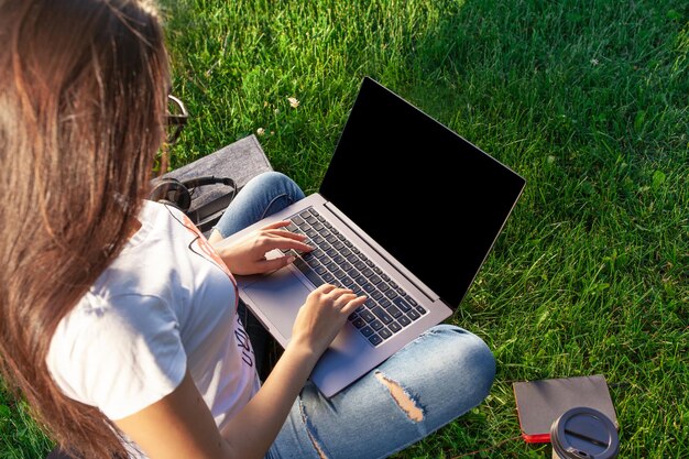 Cerrar las manos sobre el teclado mujer que trabaja en la computadora portátil pc con pantalla en blanco negra vacía para copiar ...