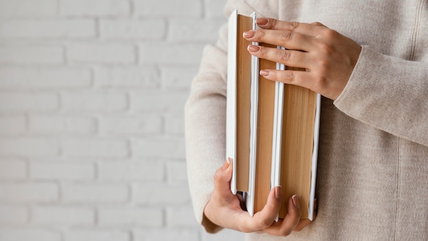 Foto cerrar manos sosteniendo libros con espacio de copia