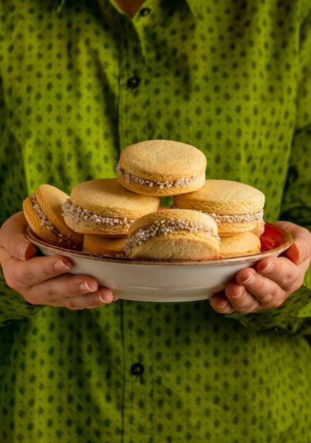 Foto cerrar las manos sosteniendo el plato con galletas