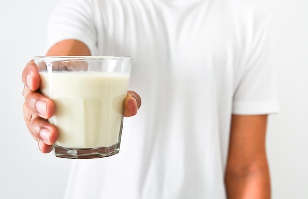 Foto cerrar mans mano sosteniendo un vaso de leche sobre fondo blanco concepto de atención médica