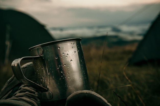 Cerrar maqueta de taza turística de metal en campamento de montaña