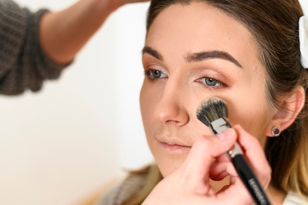 Cerrar maquilladora trabajando en maquillaje de boda