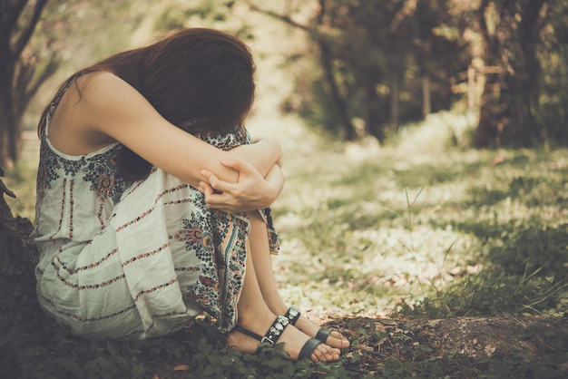 Foto cerrar mujer asiática triste sentarse bajo el concepto de niña de árbol styleheartbreak vintage