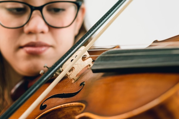 Cerrar mujer caucásica latina tocando el violín se centran en las cuerdas