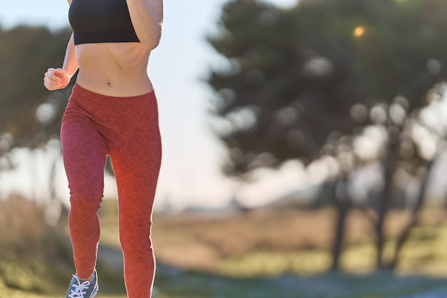 Cerrar mujer deportiva corriendo por el campo vista frontal copia espacio sun flare efecto