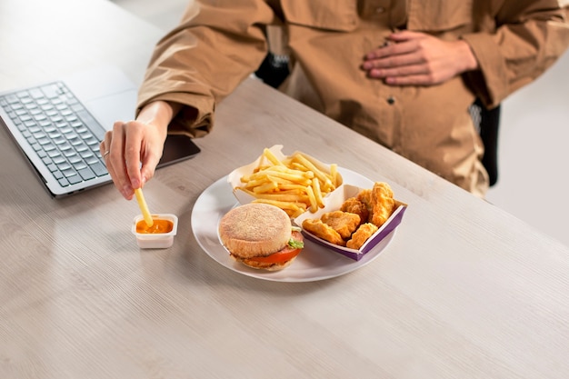 Cerrar mujer embarazada comiendo en el trabajo