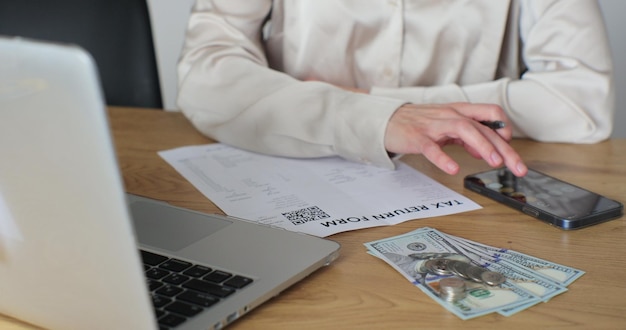 Cerrar mujer llenando formulario de declaración de impuestos Mujer calculando gastos y escribiendo en documento fiscal