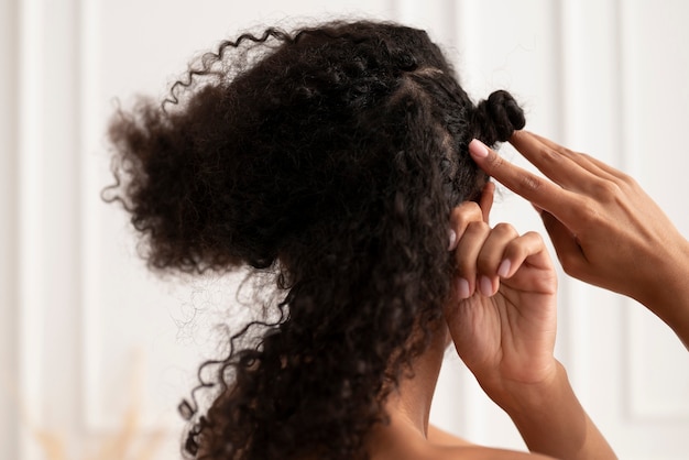 Foto cerrar mujer peinando su cabello