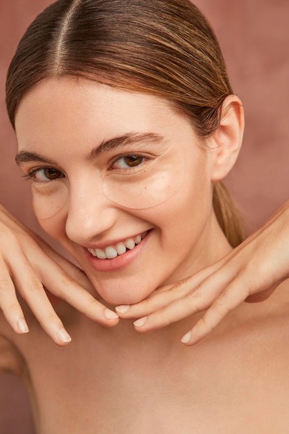 Foto cerrar mujer sonriente con parches en los ojos