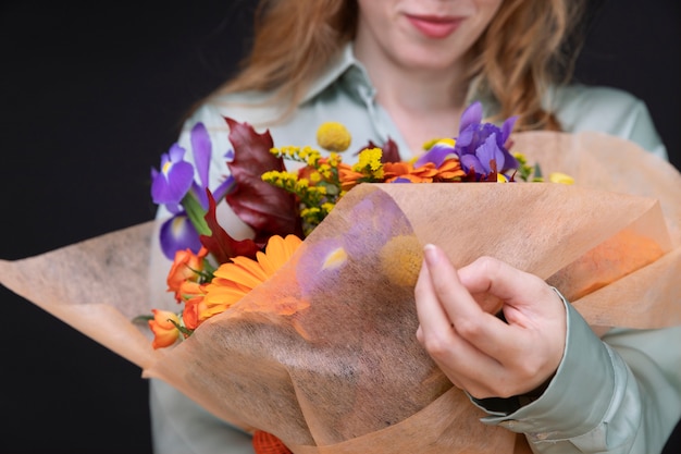 Foto cerrar mujer sosteniendo ramo de flores