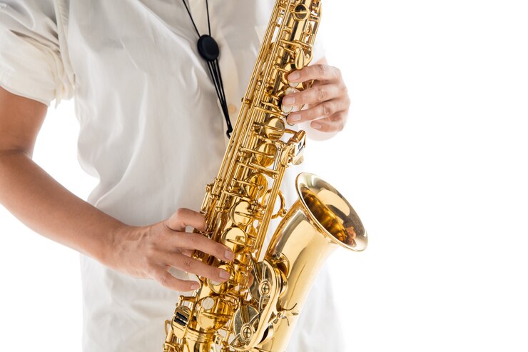 Foto cerrar mujer tocando el saxofón aislado sobre fondo blanco de estudio. músico inspirado, detalles de la ocupación artística, instrumento clásico mundial para jazz y blues. concepto de afición, creatividad.