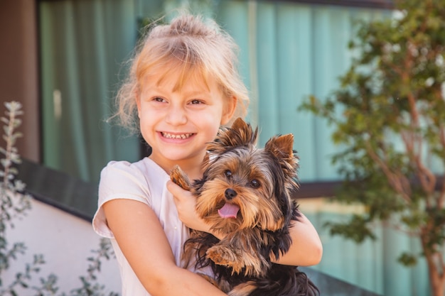 Cerrar niña sosteniendo una mascota. Niña, tenencia, un, perro