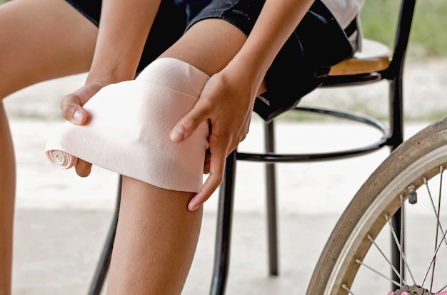 cerrar niña tocando la rodilla con vendaje elástico