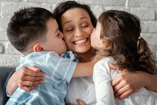 Foto cerrar a los niños besando a la madre