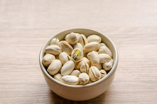 Cerrar las nueces de pistacho sobre fondo de madera