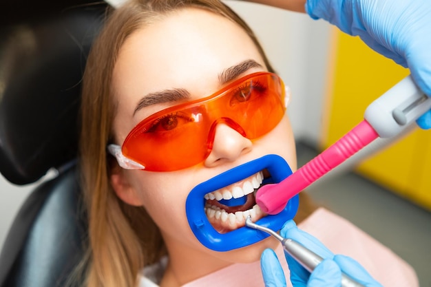 Foto cerrar a un paciente mientras hace un procedimiento profesional de limpieza de dientes en la clínica