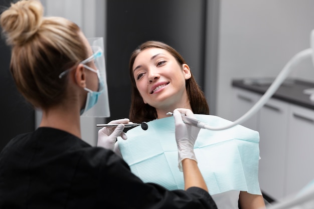 Foto cerrar paciente sonriente al dentista