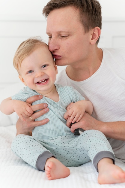 Foto cerrar padre besando a un niño