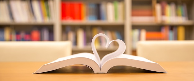 Cerrar la página del libro en forma de corazón en la biblioteca.