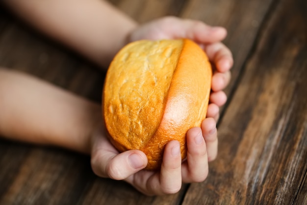 Cerrar en pan de pan en las manos del niño