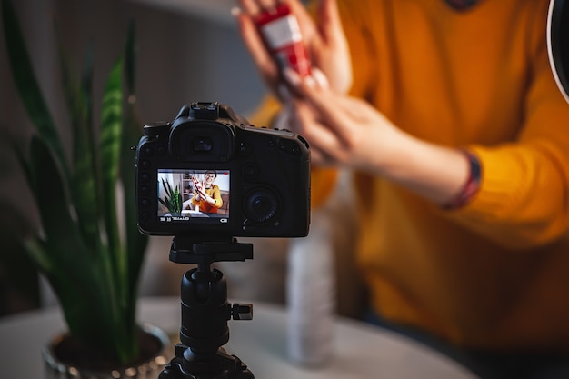 Foto cerrar la pantalla de la cámara, bloguera de belleza femenina hace revisión de video