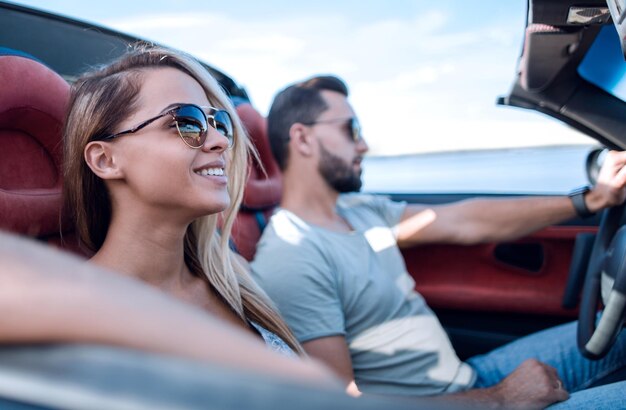 Cerrar la pareja que viaja en un descapotable