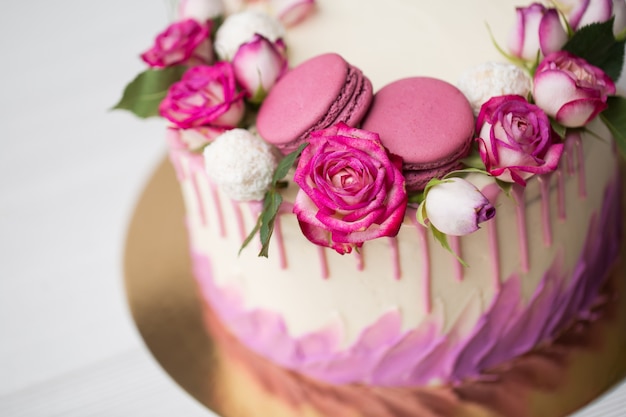 Cerrar en pastel con rosas y macarrones