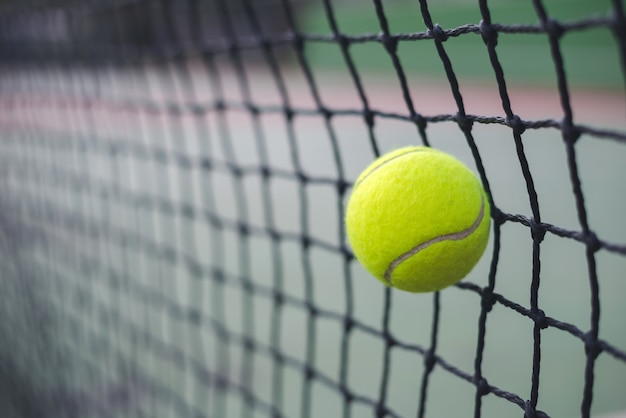 Cerrar la pelota de tenis golpeando a la red en el fondo borroso