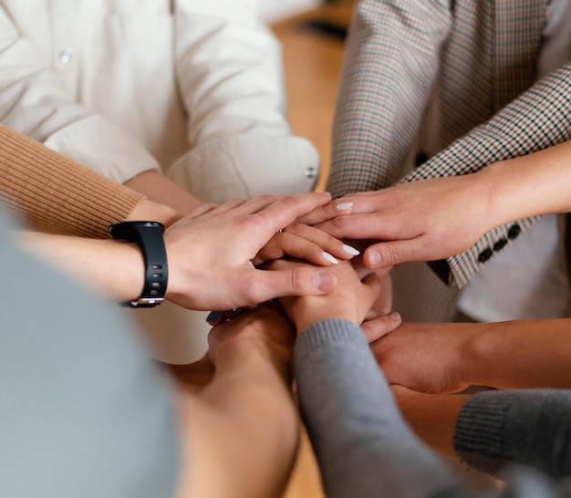 Foto cerrar personas cogidas de la mano en terapia