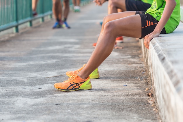 Cerrar las piernas de los corredores con zapatos de color naranja