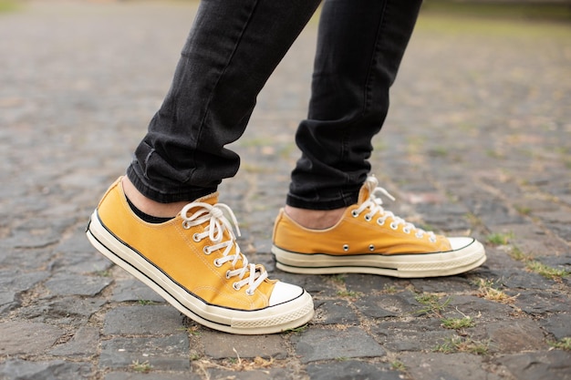 pies del hombre mientras para ir trabajo en zapatillas amarillas | Foto Premium