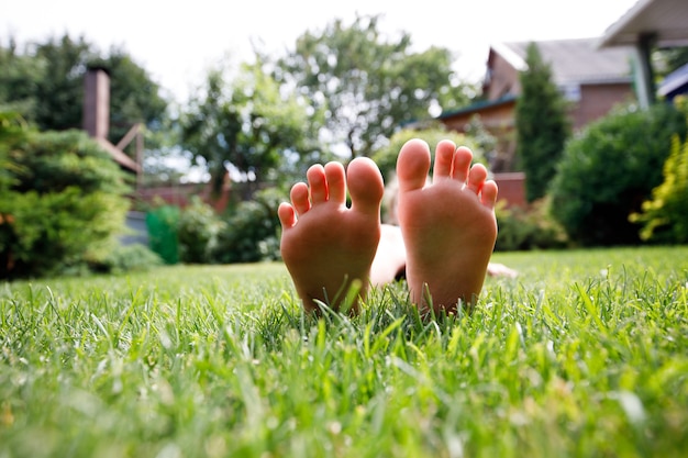 Cerrar los pies de los niños sobre la hierba verde.