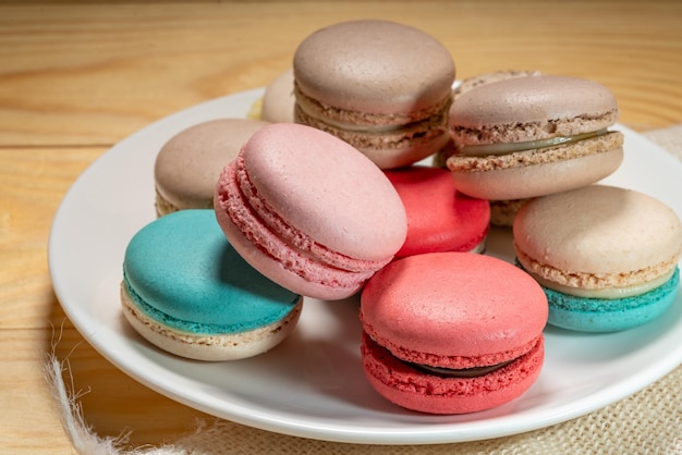 Cerrar postre macaron tonos pastel en plato blanco Macarrones dulces y coloridos