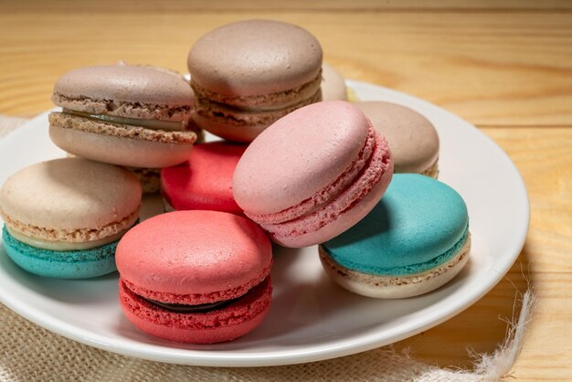 Cerrar postre macaron tonos pastel en plato blanco Macarrones dulces y coloridos