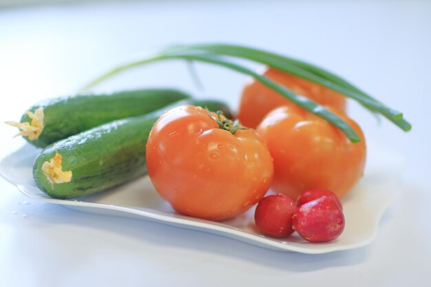 Cerrar rábanos tomates y pepinos sobre la mesa