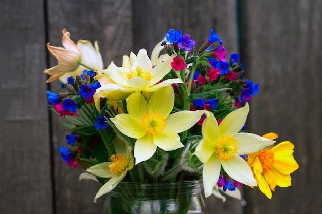 Cerrar un ramo de flores silvestres en una madera