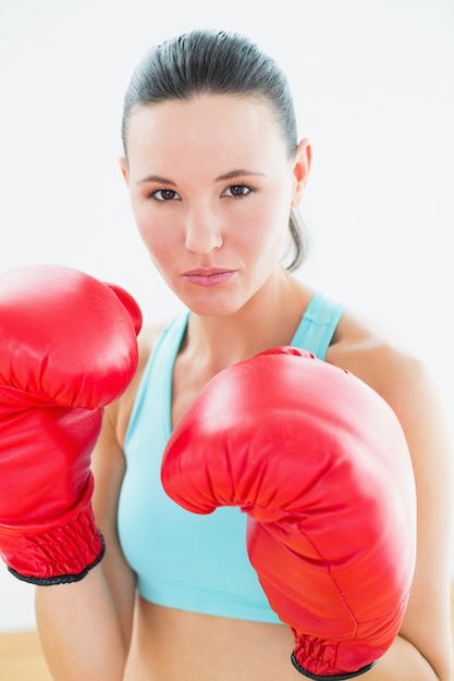 Cerrar el retrato de una bella mujer en guantes de boxeo rojos