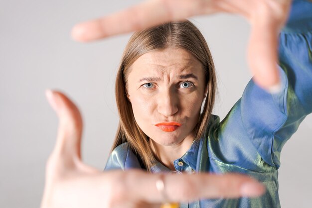 Cerrar retrato emocional encantadora mujer alegre con labios brillantes mostrar mano