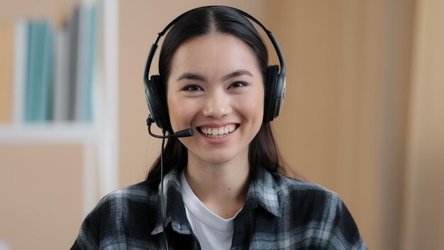 Cerrar retrato web cam ver mujer de negocios asiática usa auriculares habla con la cámara haciendo distancia