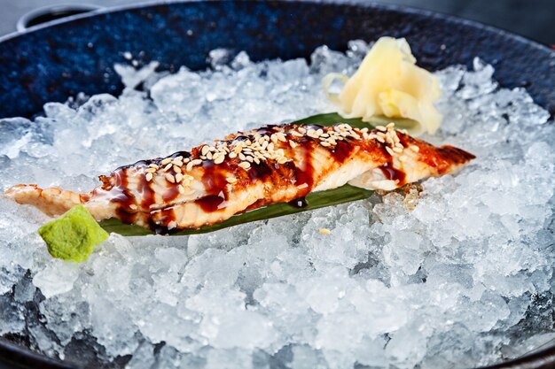 Cerrar sashimi de anguila en rodajas frescas servido en un tazón con hielo