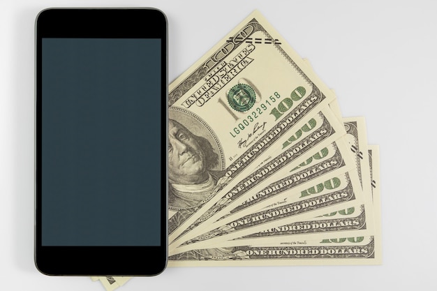 Cerrar Smartphone en billetes de cien dólares estadounidenses