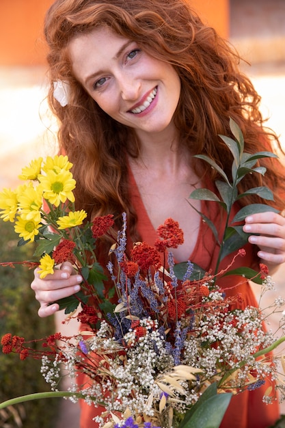 Foto cerrar sonriente mujer sosteniendo flores