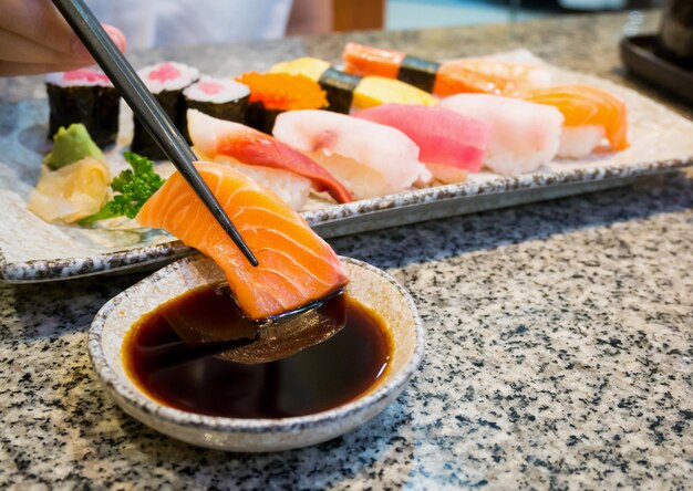 Cerrar sushi sashimi con palillos y salsa de soja